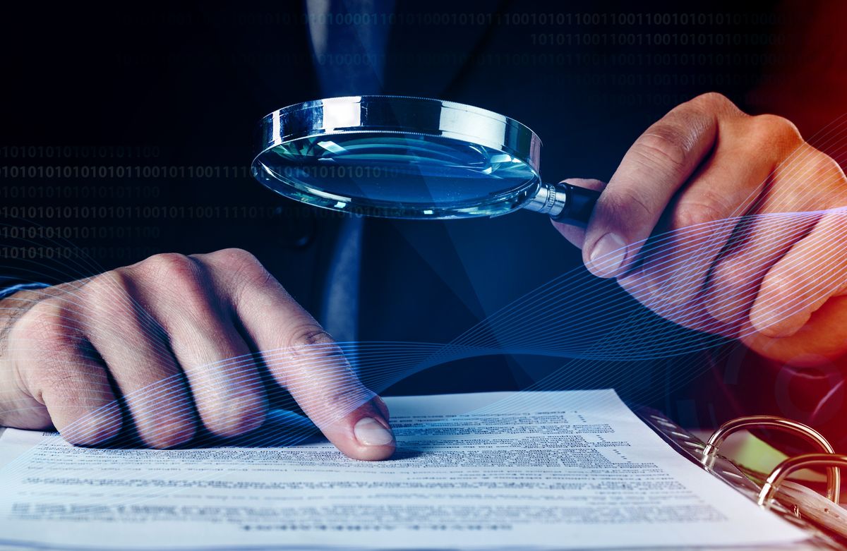 Auditor Doing Tax Fraud Investigation Using Magnifying Glass and papers